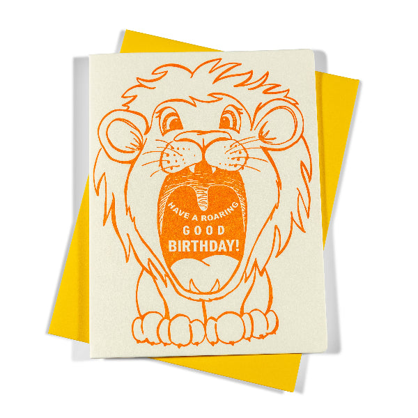 Birthday card with a lion illustration and 'Have a Roaring Good Birthday!' text on a yellow envelope.