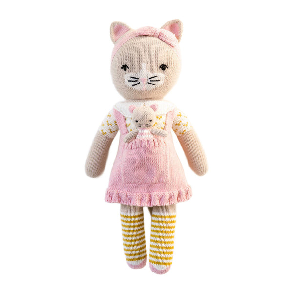 Knitted cat toy with a pink dress and striped socks