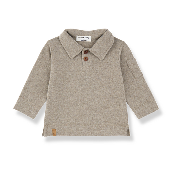A light beige heathered knit long-sleeve polo shirt for toddlers, featuring a collar with two brown buttons, a side pocket, and a small brown leather patch near the hem,