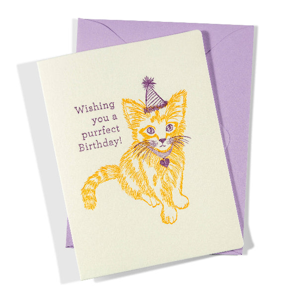 Greeting card with a cat illustration and birthday message on a purple envelope.