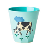Children's cup with a cow design on a light blue background