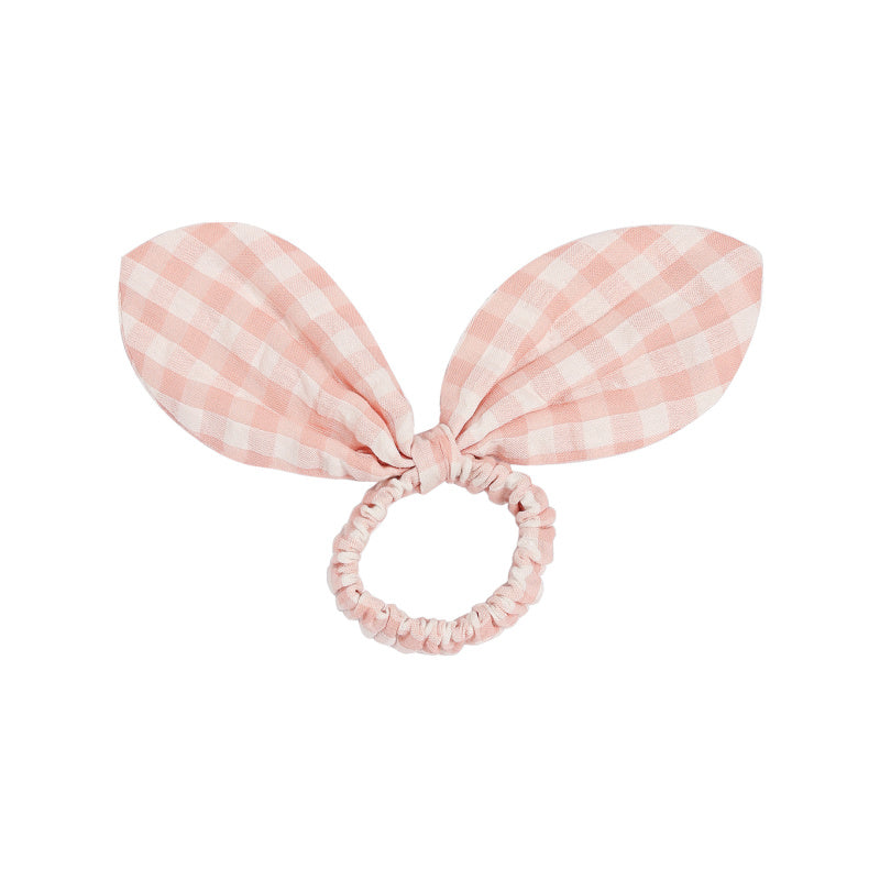 Pink checkered bunny ear hair tie on a white background