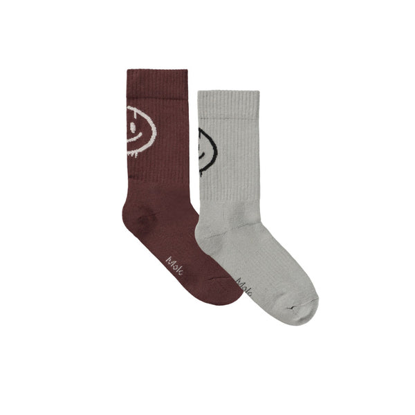 Two socks, one brown and one gray, with smiley face designs 