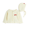 A baby knit clothing set featuring a cream ribbed cardigan and matching bonnet, both with a small red car embroidery on the front,