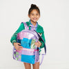 girl with a big smile holds her state bag kane kids double pocket large backpack in patchwork in front of her.
