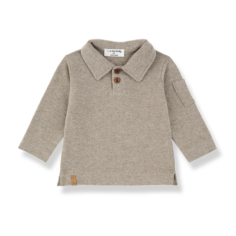 A light beige heathered knit long-sleeve polo shirt for toddlers, featuring a collar with two brown buttons, a side pocket, and a small brown leather patch near the hem,