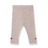 A pair of ribbed knit baby leggings in a light taupe-beige color, featuring small brown wooden buttons on the cuffs