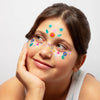 Young girl with colorful temporary tattoos on her face omy face stickers flowers