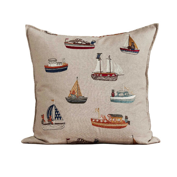 Decorative pillow with boat patterns on a wooden surface and beige background